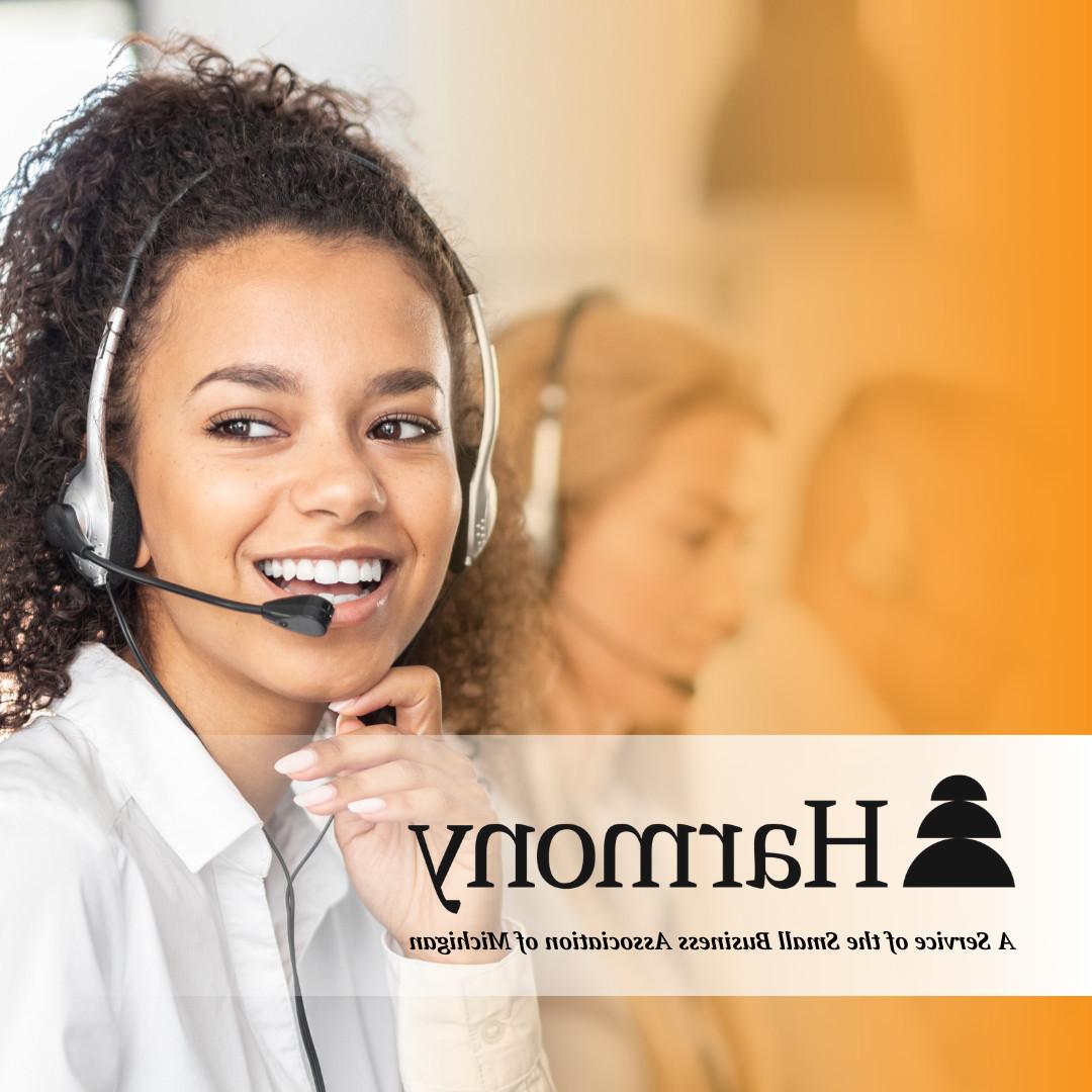A smiling woman with a headset on ready to take calls.